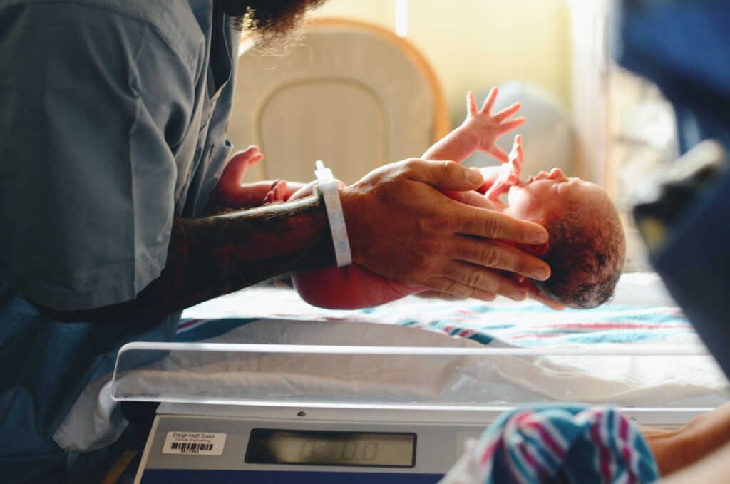 a person putting the baby on the scale