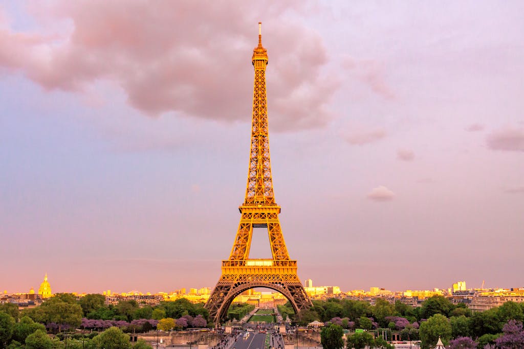 Capture of the Eiffel Tower in Paris at dusk with a vibrant sky, showcasing its iconic structure.